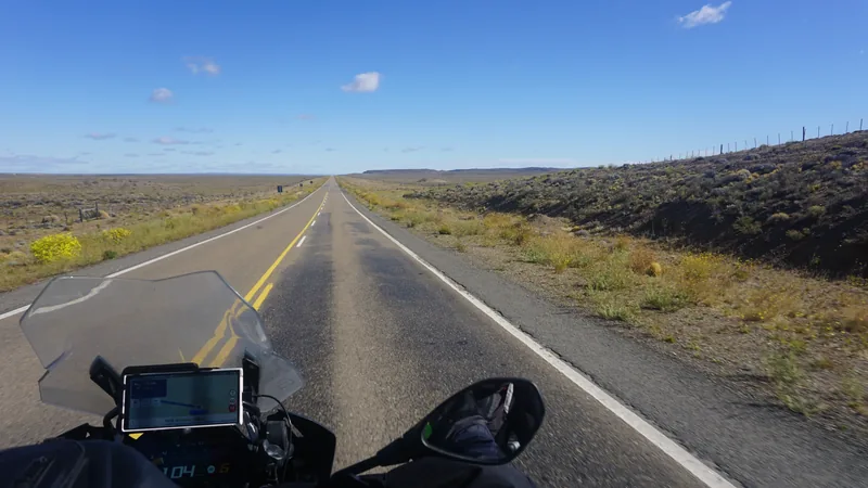 Vista da estrada a partir da moto, com a tela de navegação no canto inferior da imagem.