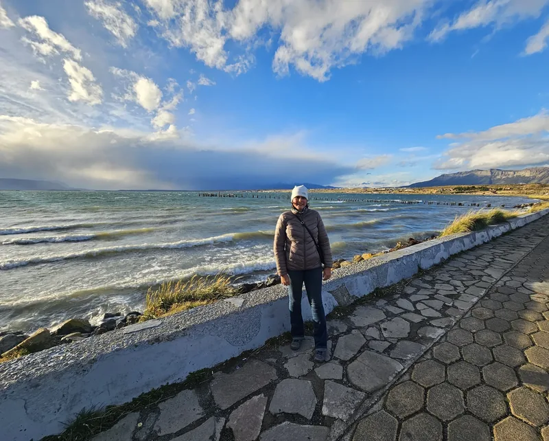 Denise na orla de Puerto Natales, com a água ao fundo.
