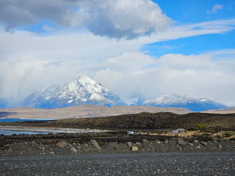 Montanha nevada, água e estrada de cascalho em Torres del Paine.